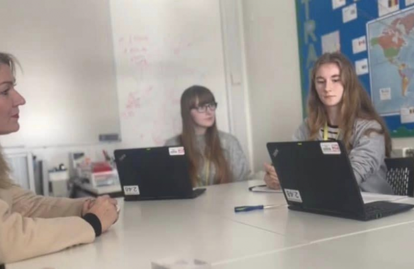 Laura sat at table with students