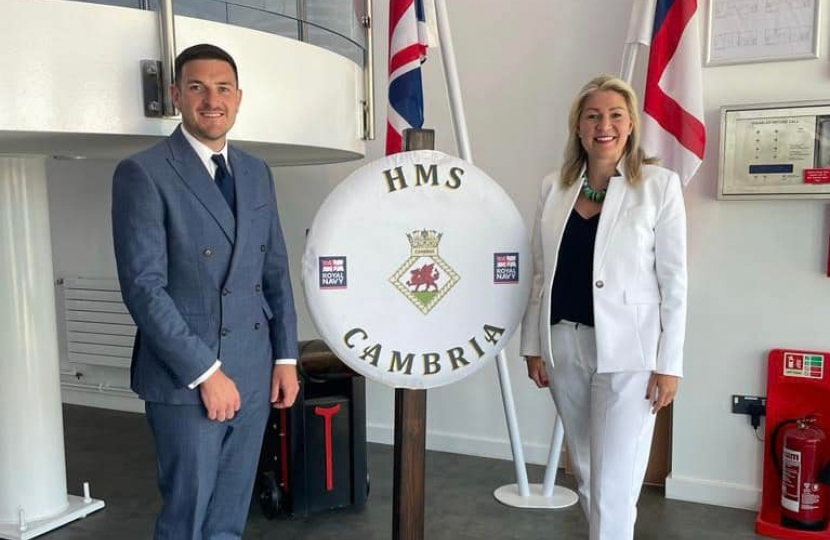 Laura Anne Jones MS and James Evans MS pictured in front of HMS Cambria sign